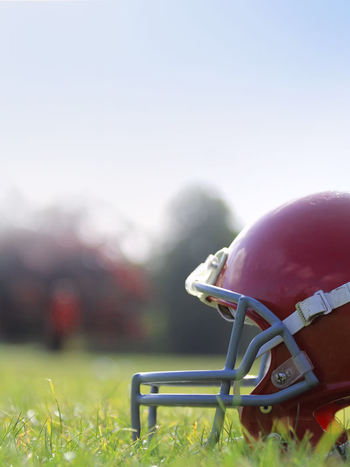 American-Football-Helm auf dem Rasen – Hintergrund zu Finanzpaketen.