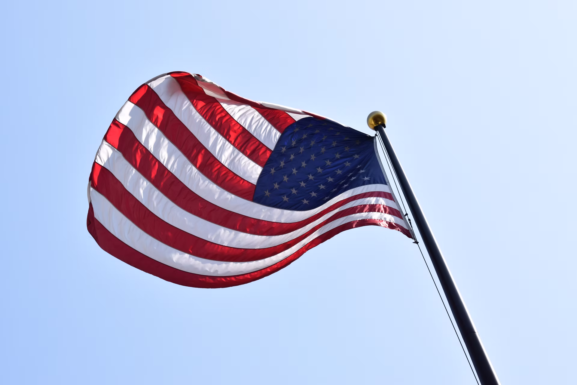 Flagge der USA vor blauem Himmel.