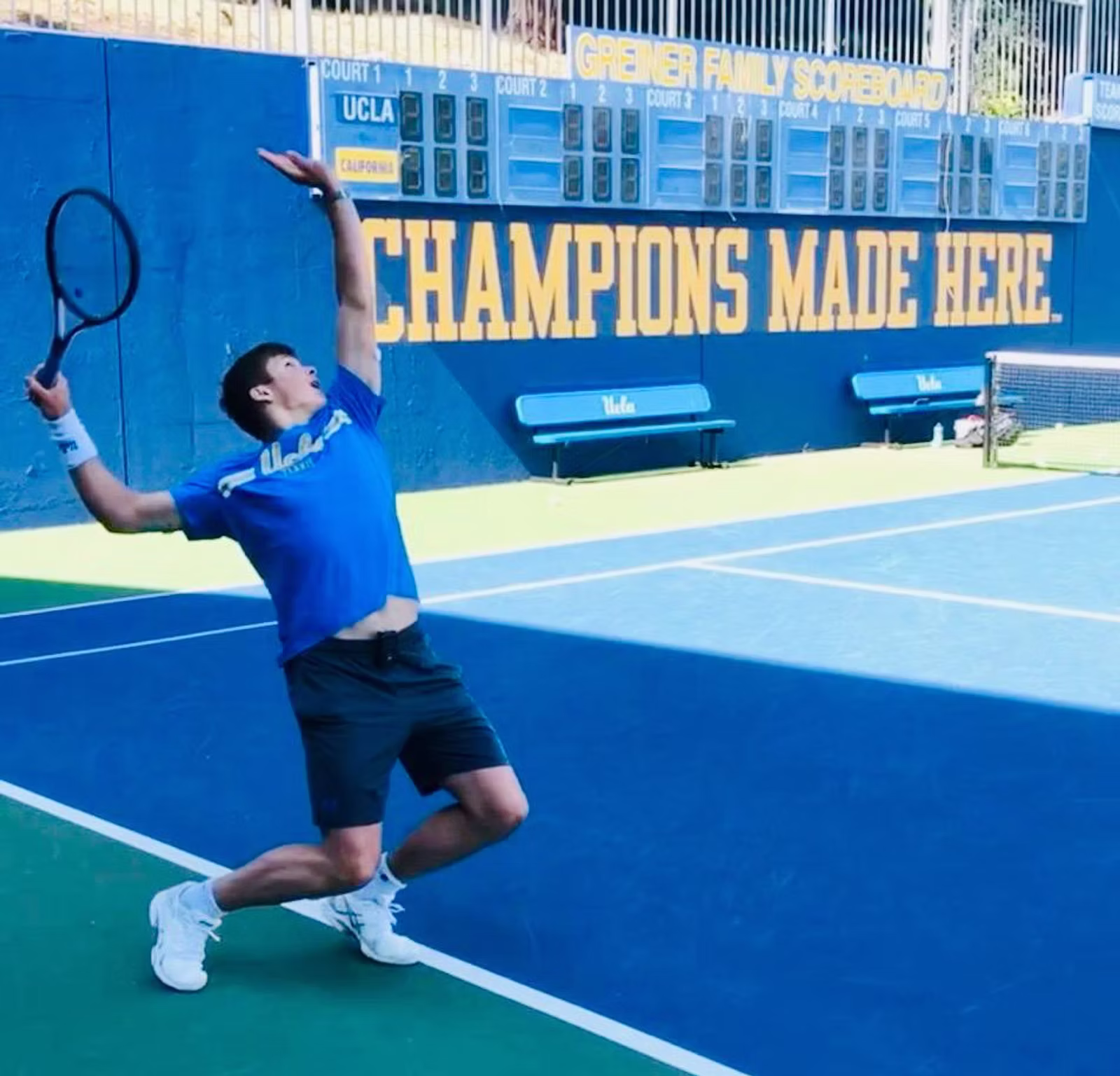 Tennis player serving on a blue tennis court with a precise stance.