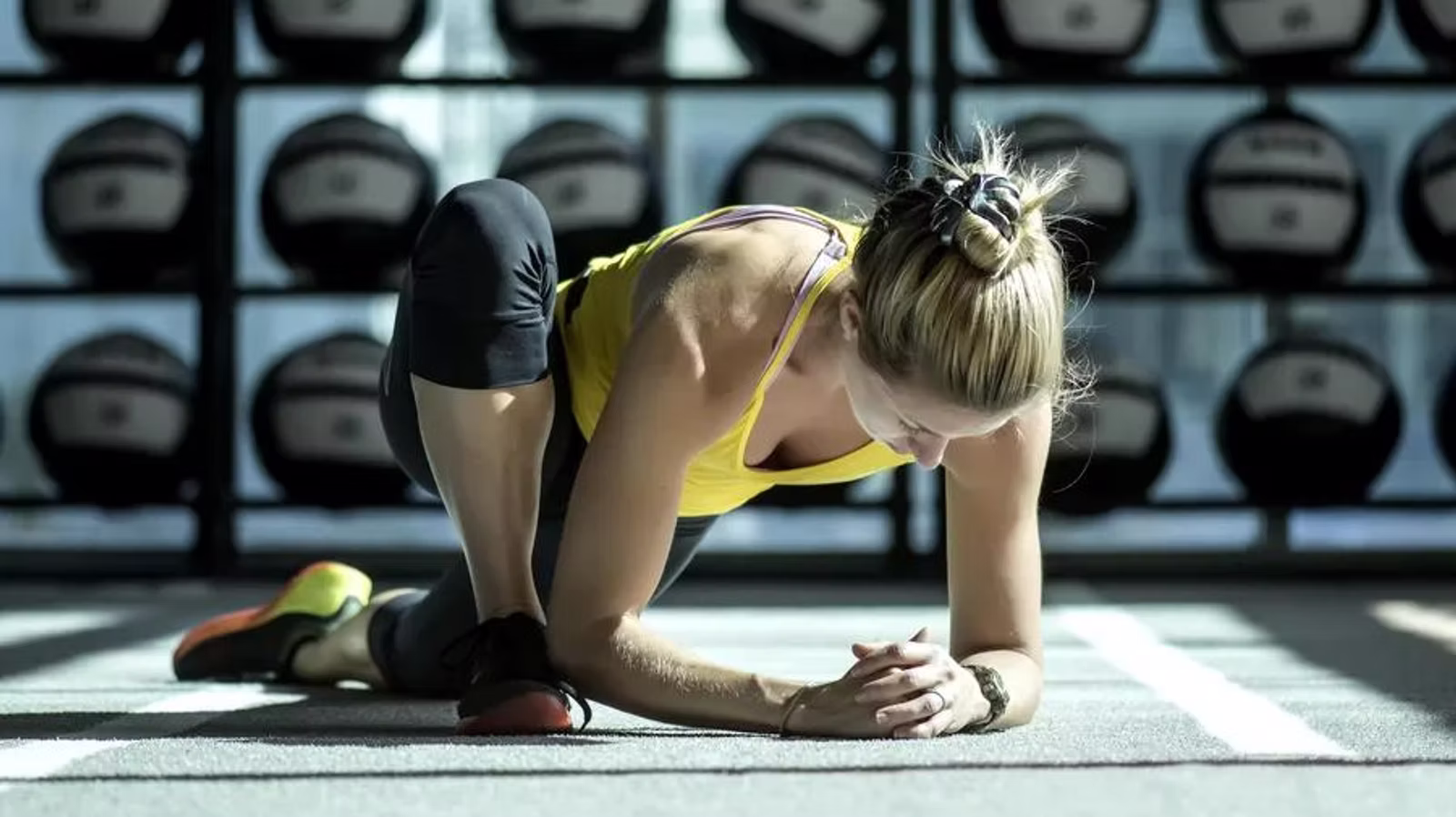 Athlete stretching in a gym for mobility and athletic conditioning.
