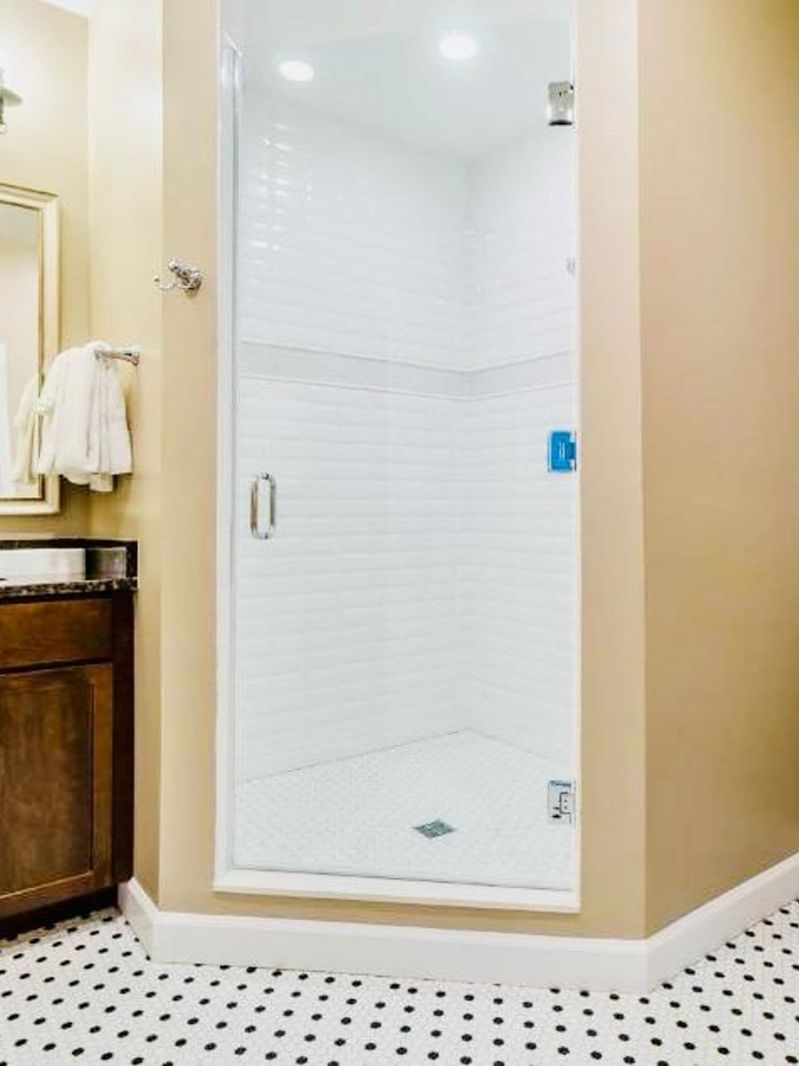 Athlete housing — bathroom with vanity, shower enclosure and tiling.