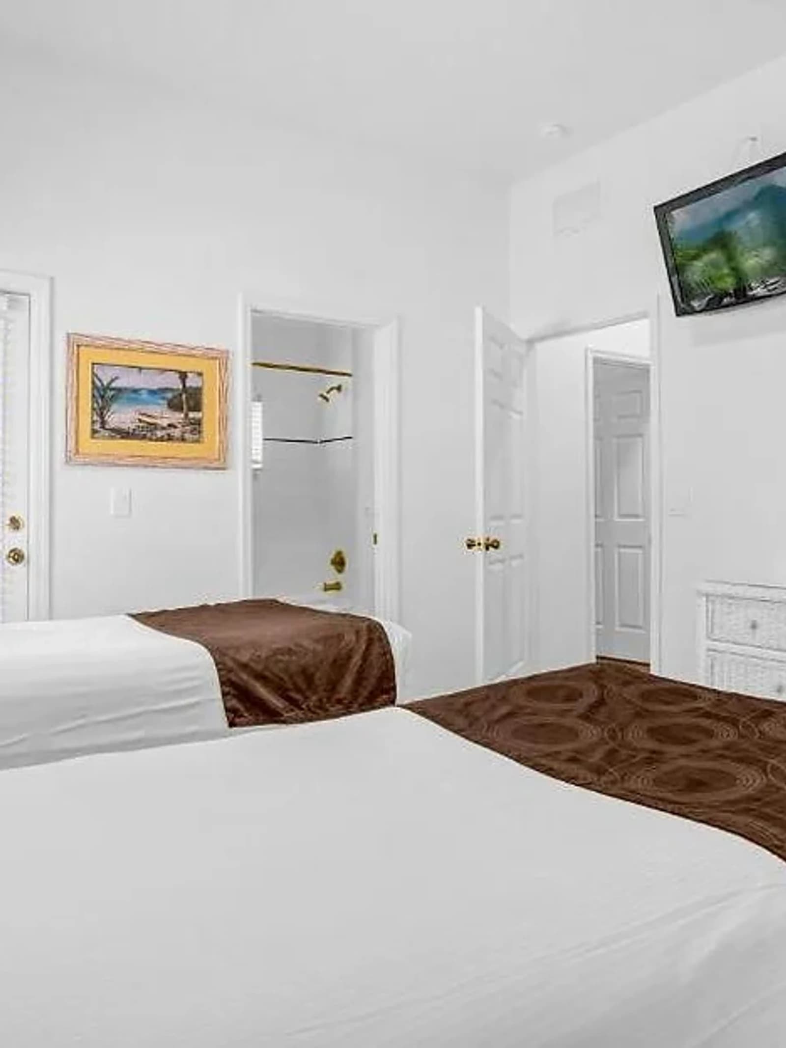 Athlete accommodation — twin-bed bedroom with wardrobes and dresser.